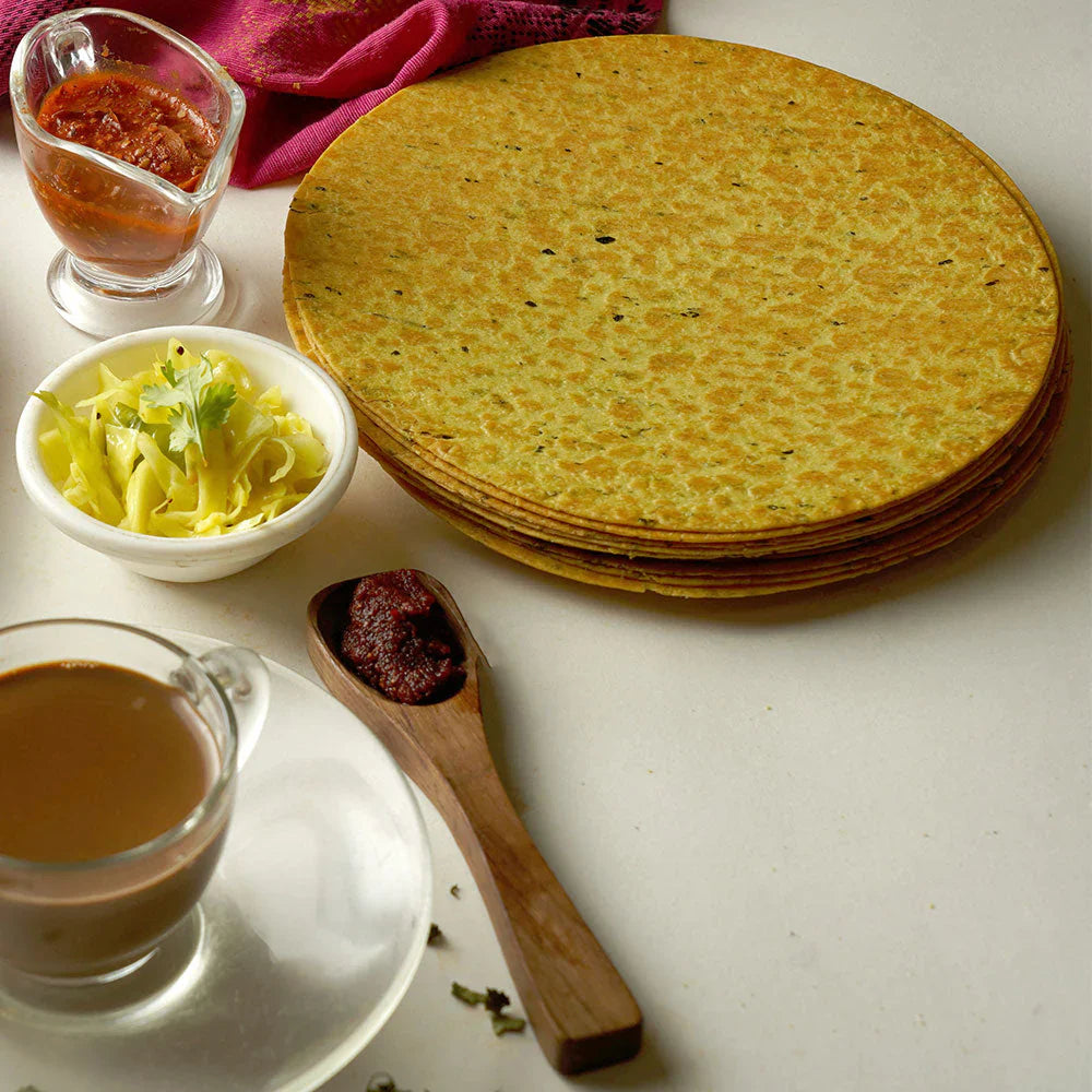 Close-up of a crispy round Indian snack, emphasizing its thinness.