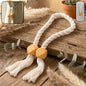 Magnetic curtain tieback with braided rope and decorative beads.