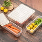 A set of three transparent plastic food storage containers with blue lids, stacked neatly in a fridge.