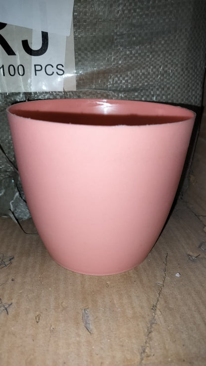 Round plastic planter in a modern indoor setting, demonstrating its versatility.
