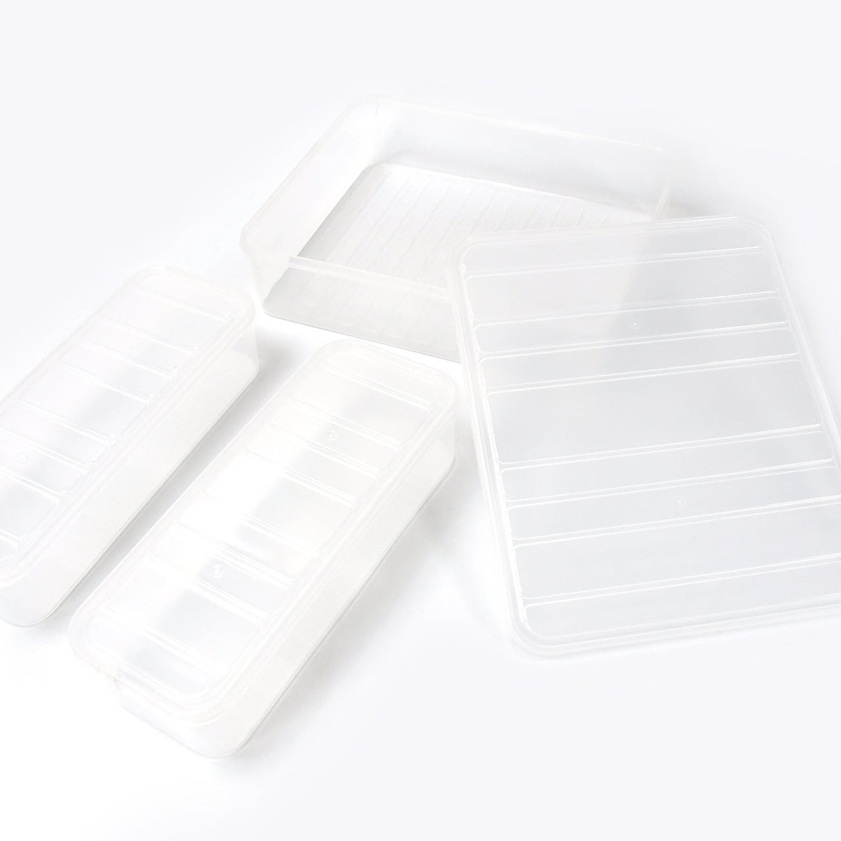 A person placing a transparent plastic food storage container filled with food into a refrigerator.