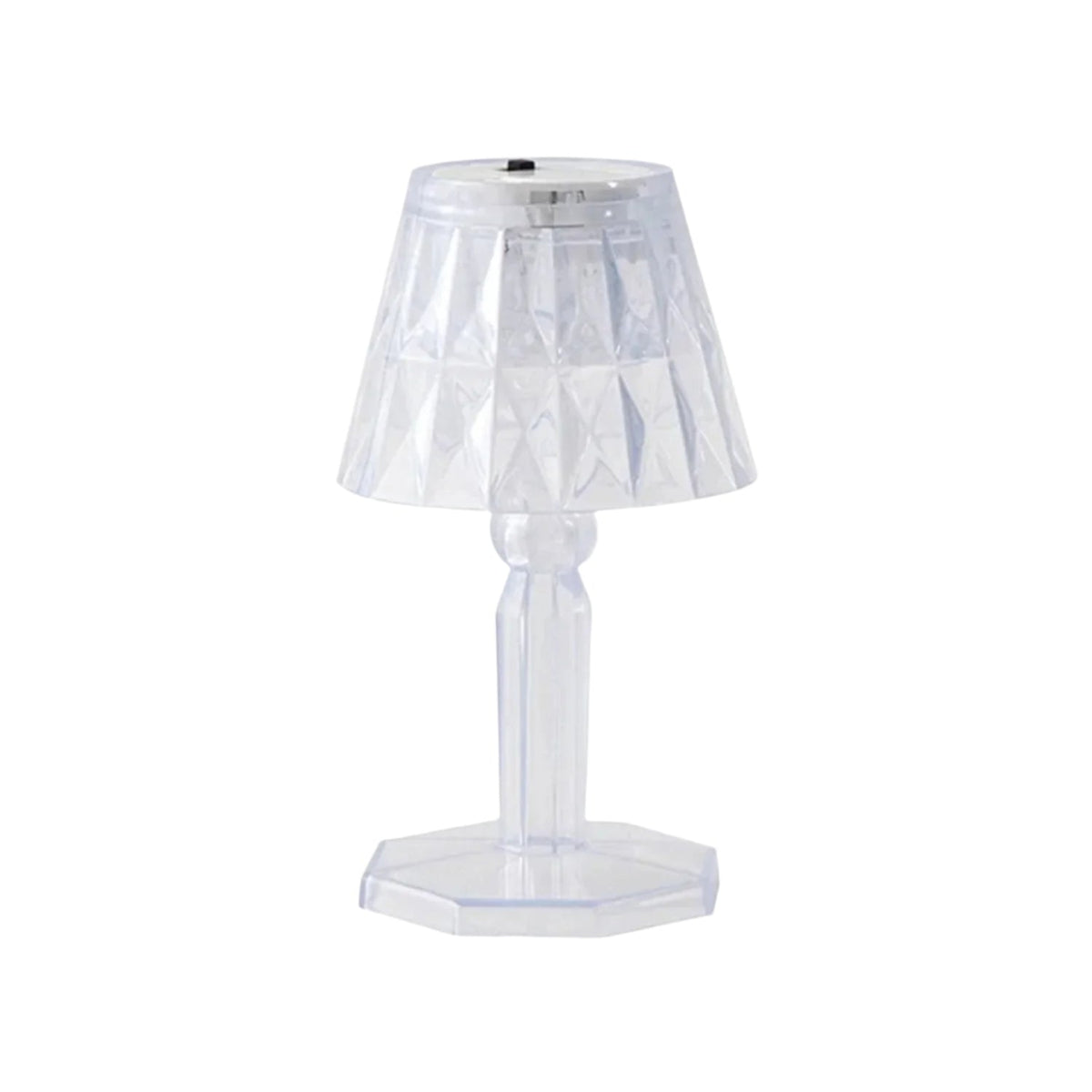 A compact crystal table lamp reflecting light onto a wall.