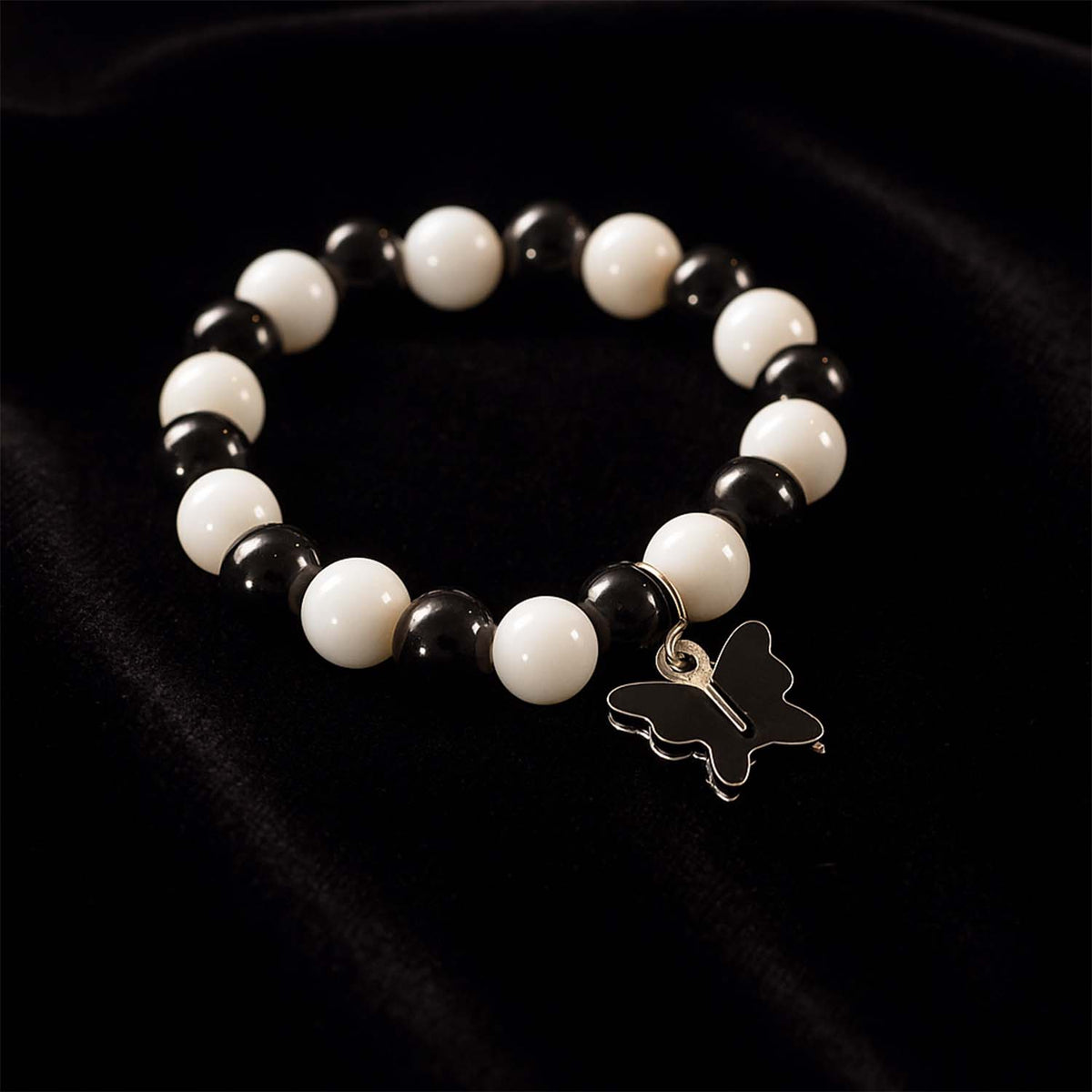 Close-up of black and white beads and cross pendant on bracelet